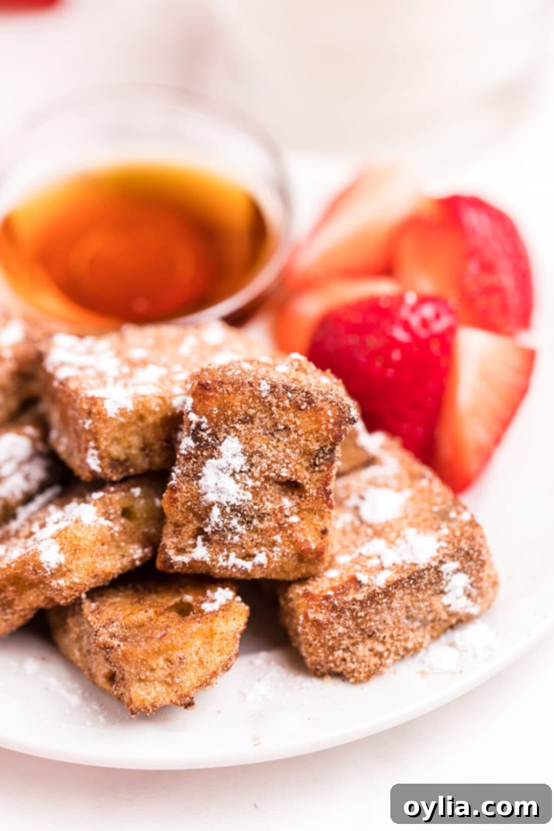 plate of Air Fryer French Toast Bites with strawberries on the side