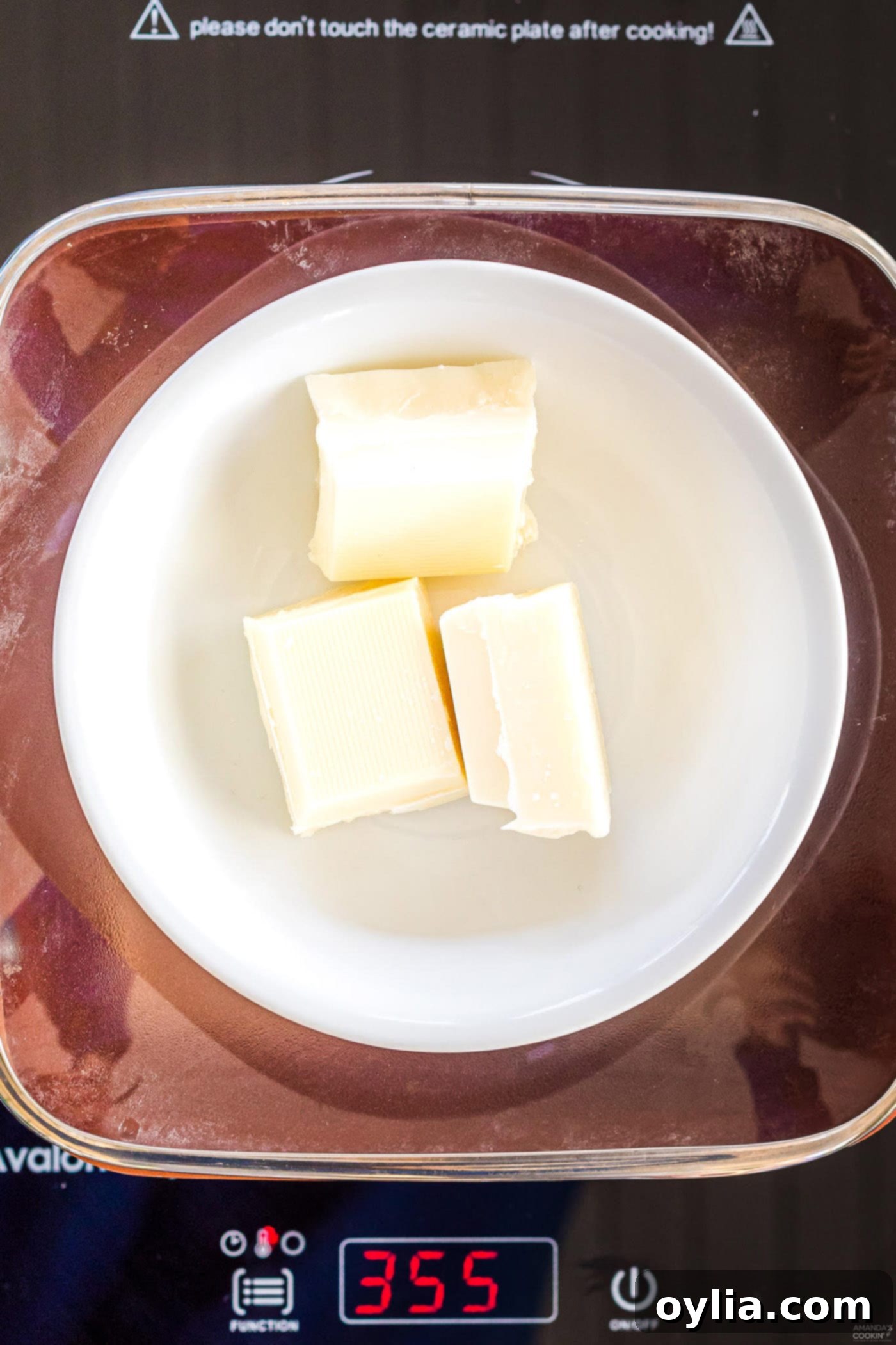 White chocolate melting in a double boiler, showing its smooth, creamy consistency, ideal for making hot cocoa bomb shells.