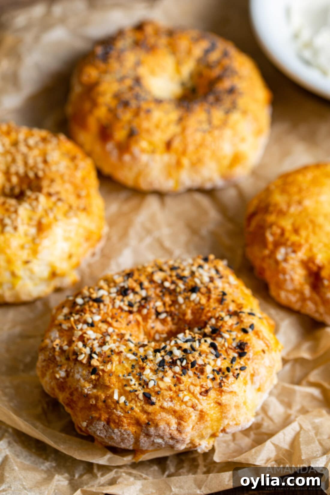 Perfect Air Fryer Bagels 2 Freshly baked air fryer bagels resting on parchment paper, ready to be served or topped.