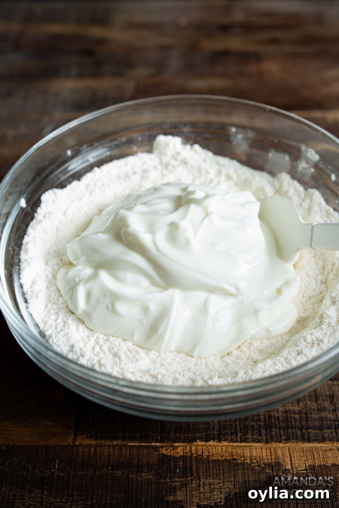 Dry ingredients for air fryer bagels in a bowl with a spoon, showing the shaggy dough stage.