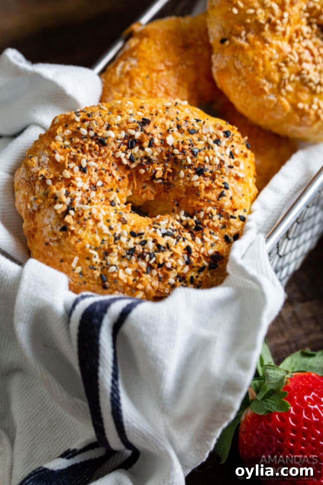 Perfect Air Fryer Bagels 10 Four golden brown air fryer bagels stacked neatly in an air fryer basket.