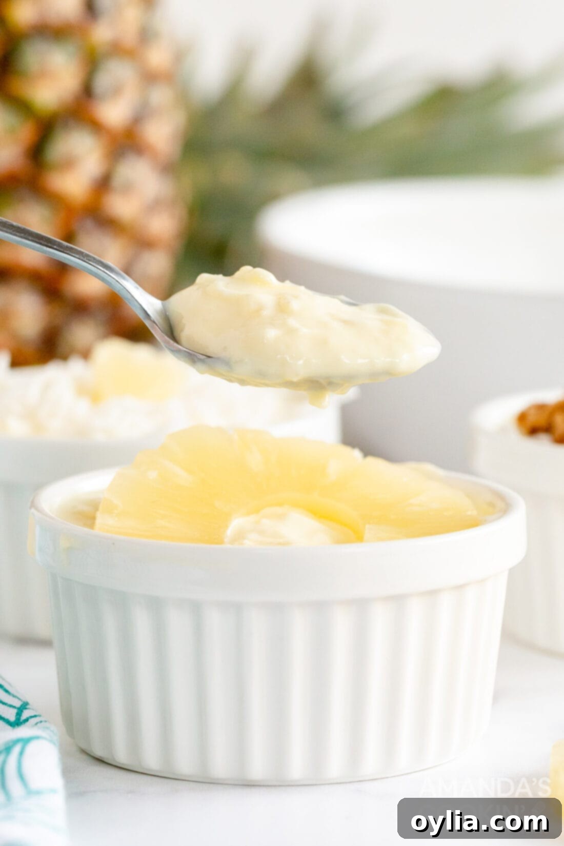 Tropical Yogurt Delight 7 lifting spoon from pineapple yogurt dessert with a dollop of whipped cream