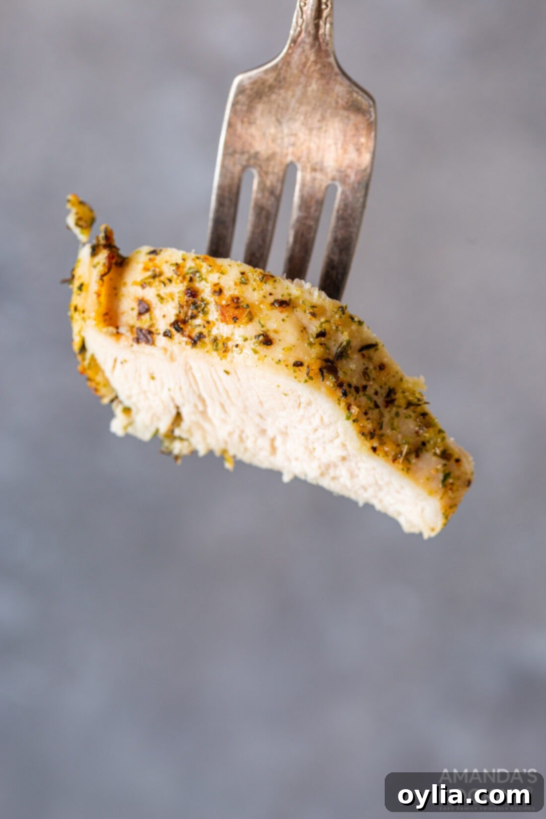 fork with a piece of chicken, showing the juicy interior of an air fried chicken breast