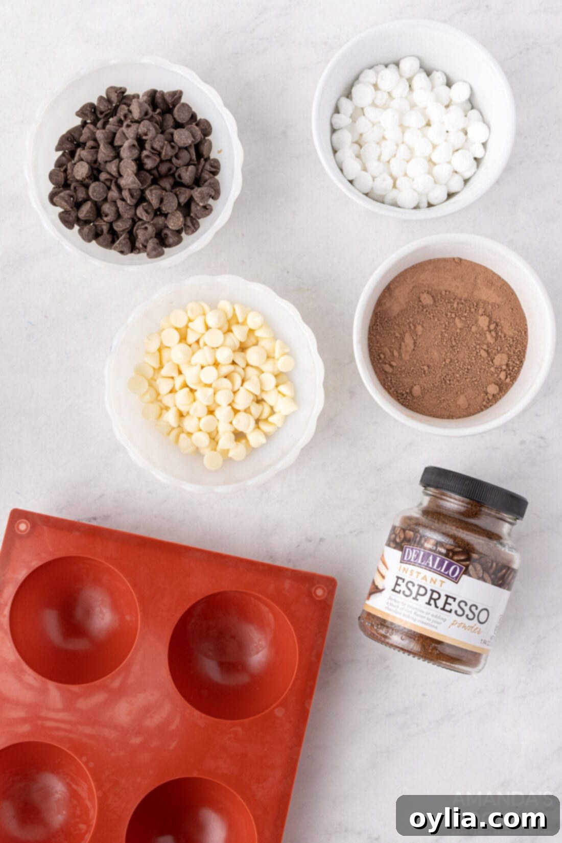 A curated selection of ingredients laid out, including semi-sweet chocolate chips, white chocolate chips, hot cocoa powder, instant espresso powder, and mini marshmallows, ready for making mocha hot cocoa bombs.