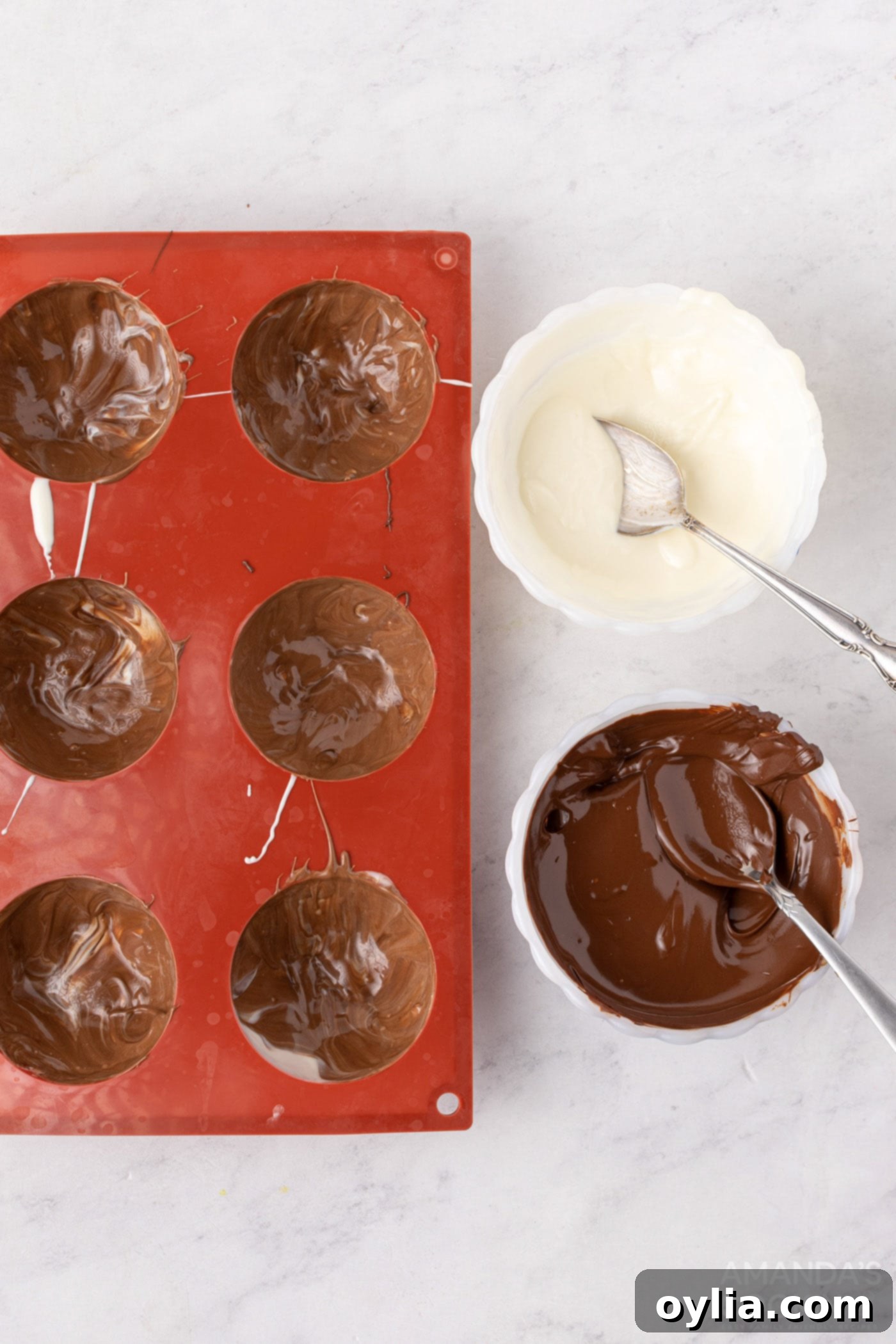The marbled chocolate half-spheres are shown hardened in their molds, with reinforced edges for better structural integrity.