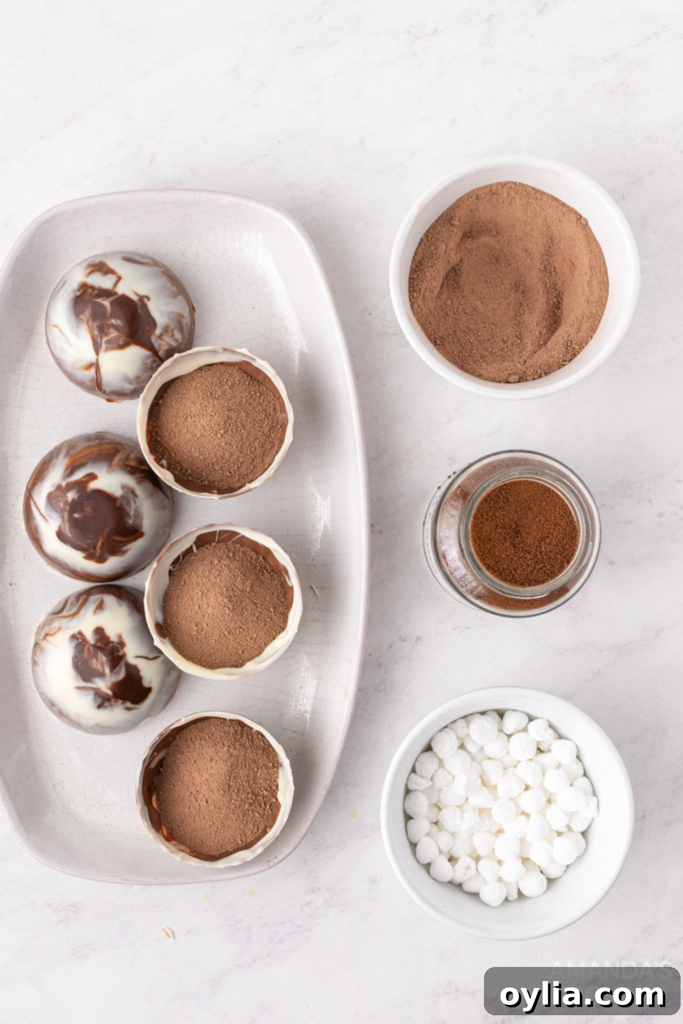 Six chocolate half-spheres are filled with generous amounts of hot cocoa mix, ready for the next layer of ingredients.