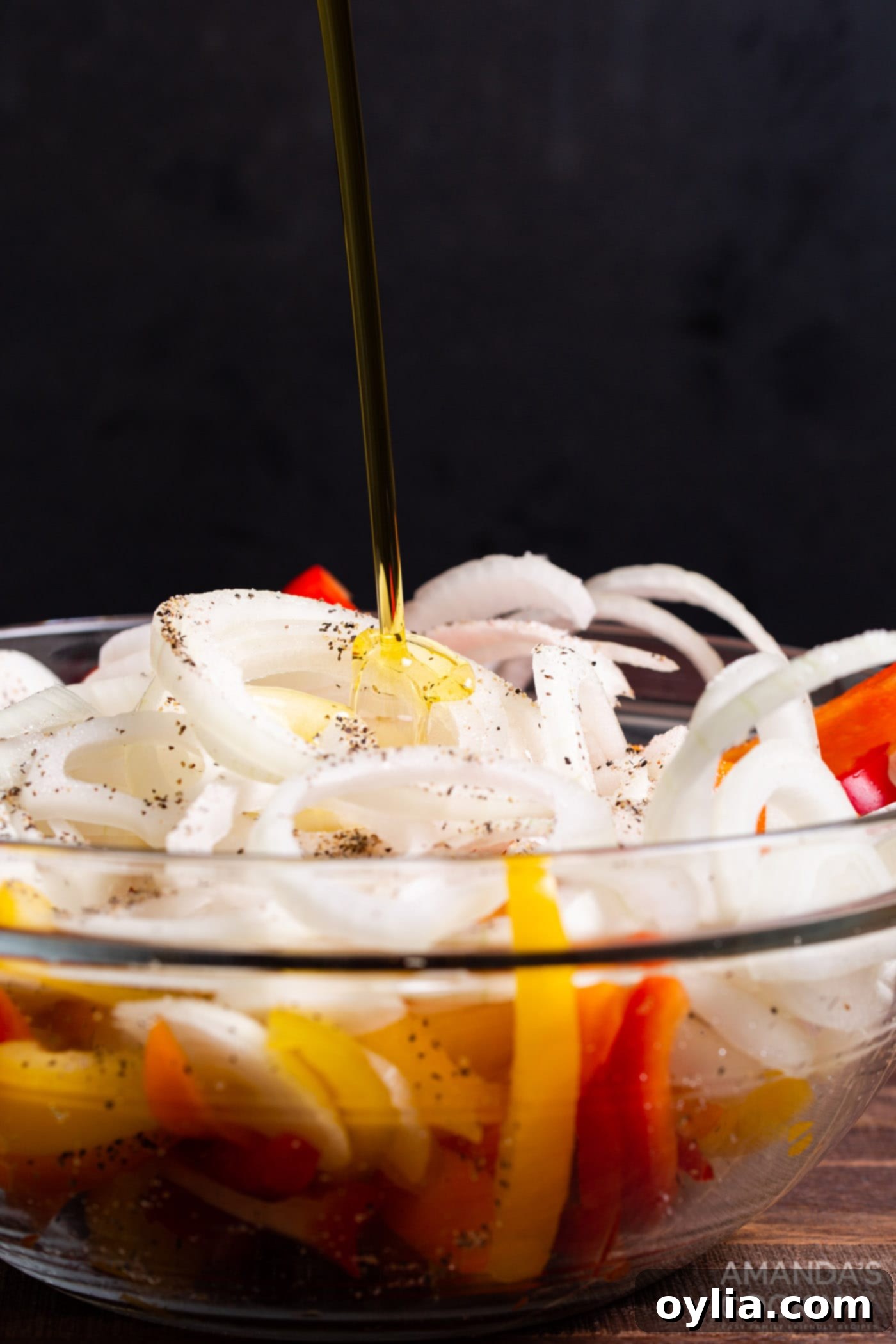 olive oil added to a bowl of peppers