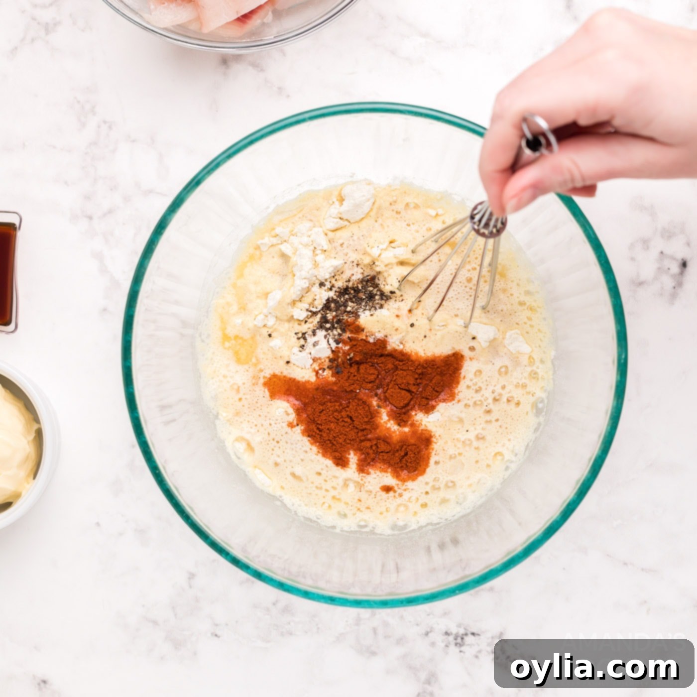 Adding pepper, salt, and paprika to the beer batter