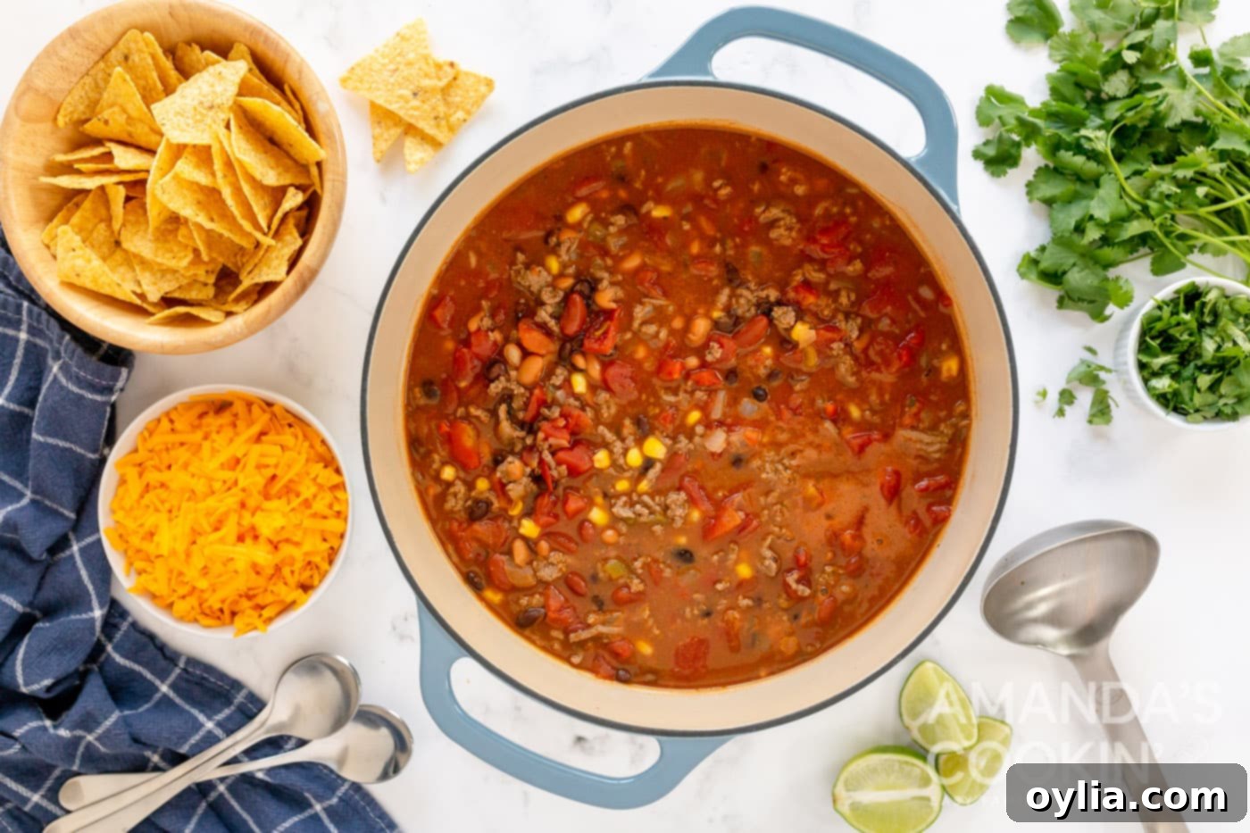 The taco soup simmering gently in the Dutch oven, with steam rising and colors vibrant, nearing completion.