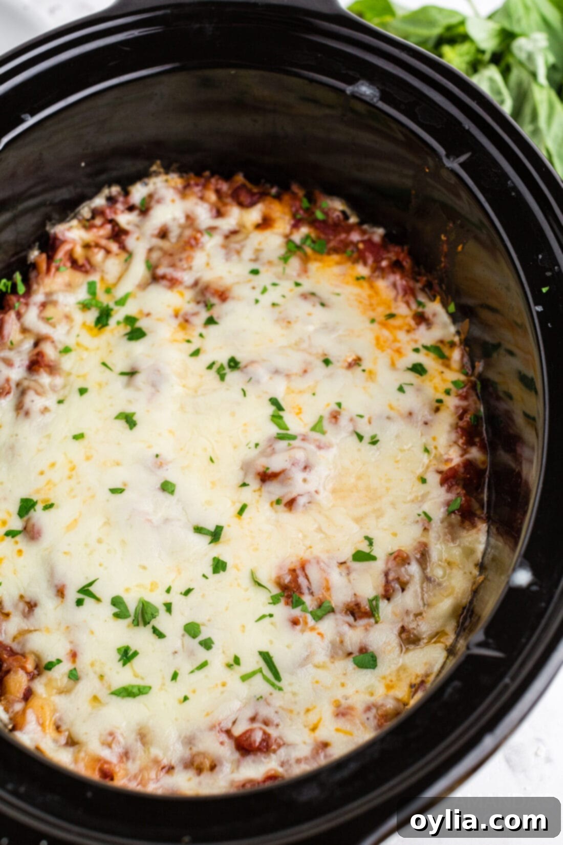 Set It and Forget It Lasagna 2 Classic lasagna layered in a crockpot, featuring rich meat sauce, creamy ricotta, and melted mozzarella and Parmesan cheeses, ready to cook.