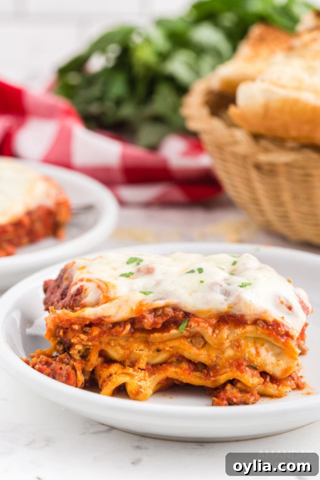 Set It and Forget It Lasagna 12 A perfectly portioned slice of crockpot lasagna on a white plate, showcasing its distinct layers of meat, cheese, and noodles, garnished with fresh parsley.