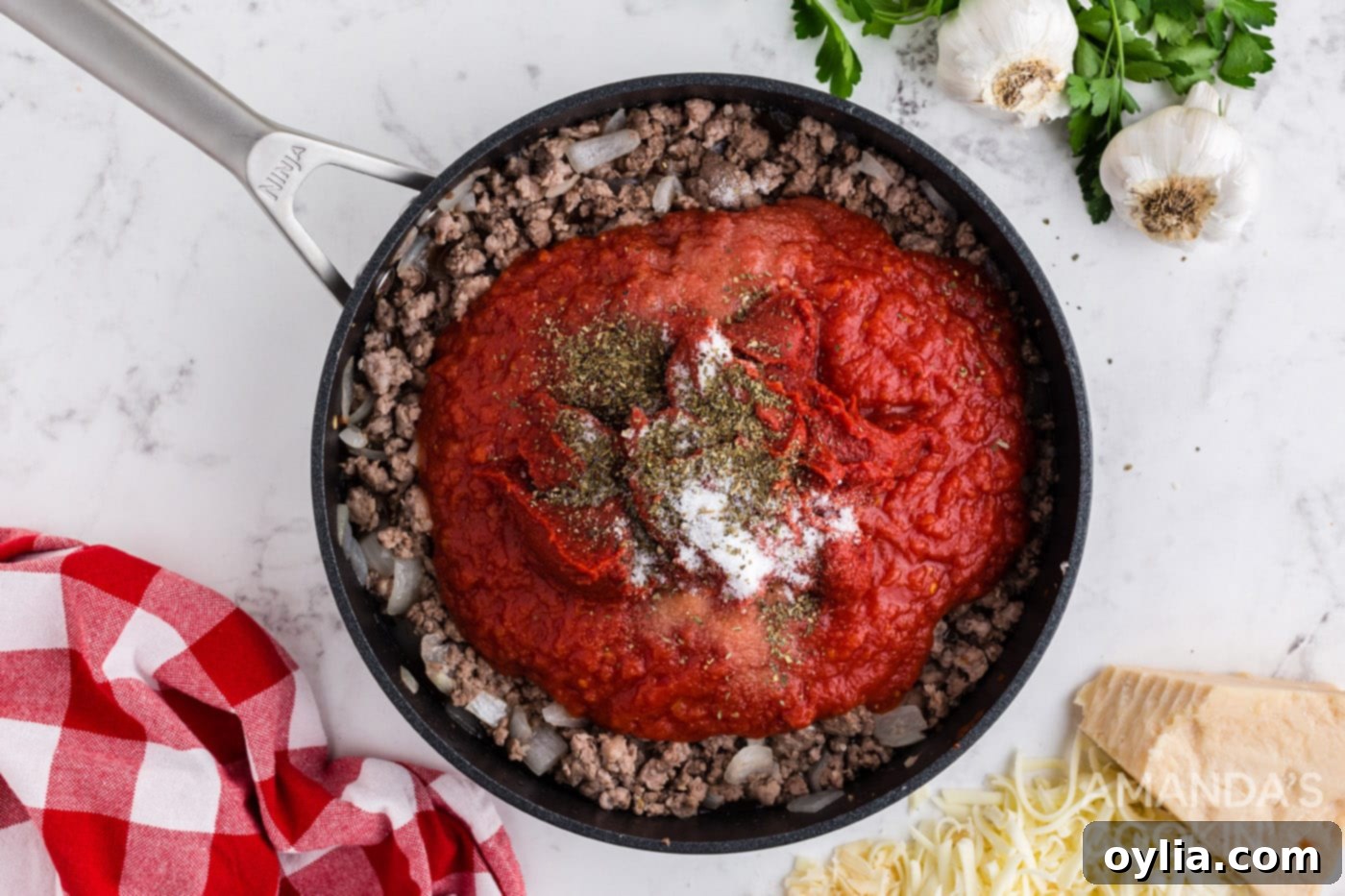Set It and Forget It Lasagna 5 Rich tomato meat sauce cooking in a skillet with a spoon, ready for layering into the crockpot lasagna.