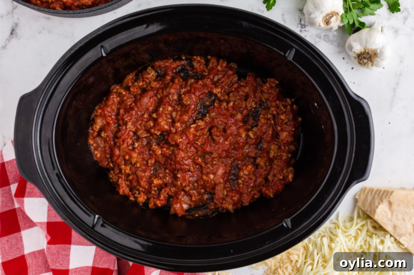 Set It and Forget It Lasagna 7 A generous layer of rich meat sauce spread evenly at the bottom of a slow cooker.