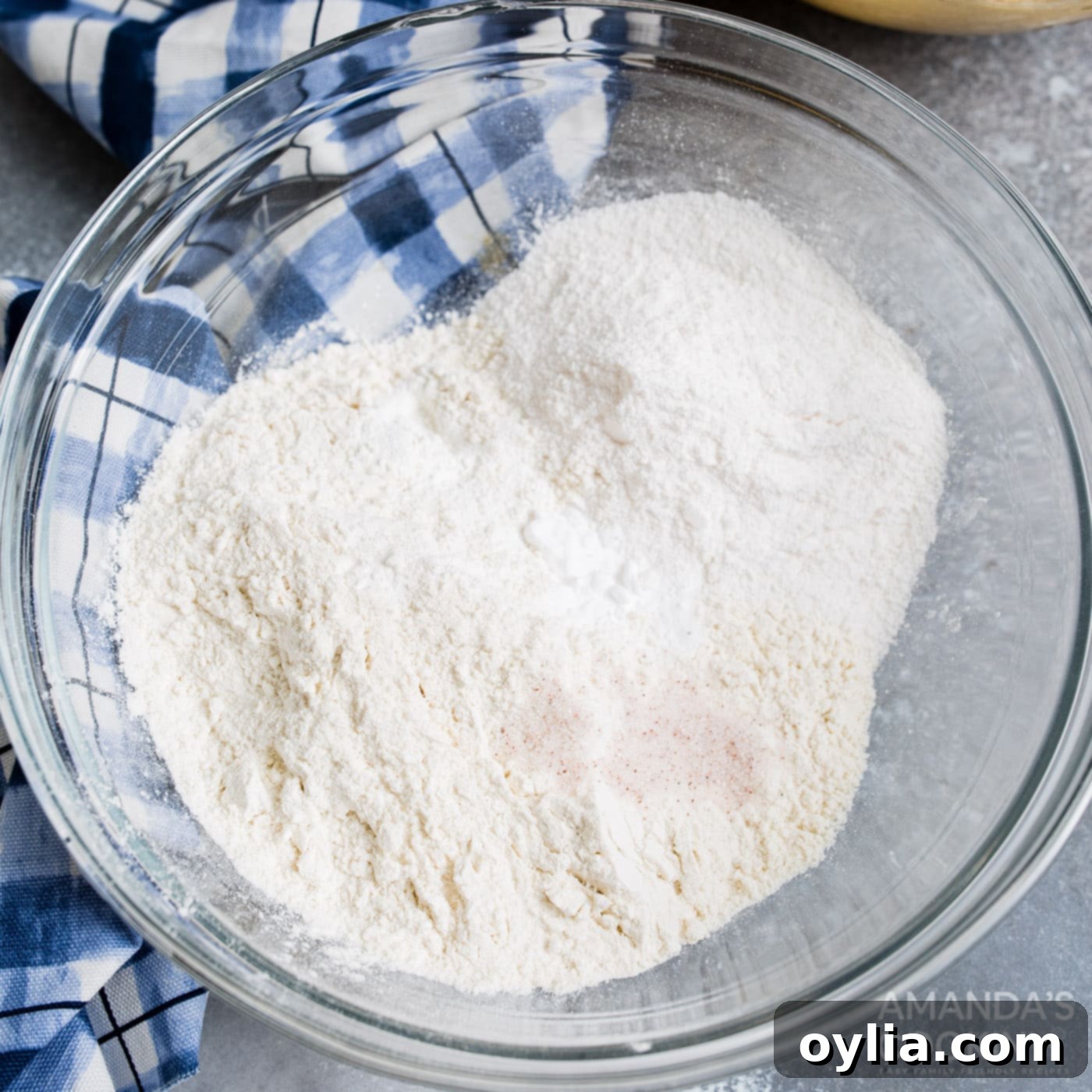 Dry cookie ingredients including flour, baking soda, baking powder, salt, and pudding mix in a mixing bowl.