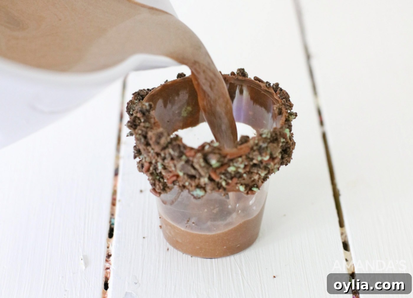 Image showing the chocolate alcohol mixture being poured into a rimmed shot glass.