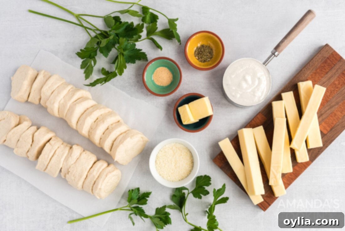 Ingredients laid out on a table for making Easter bunny pull apart bread: biscuits, mozzarella cheese, butter, garlic powder, Italian seasoning, parsley, parmesan, and ranch dressing.