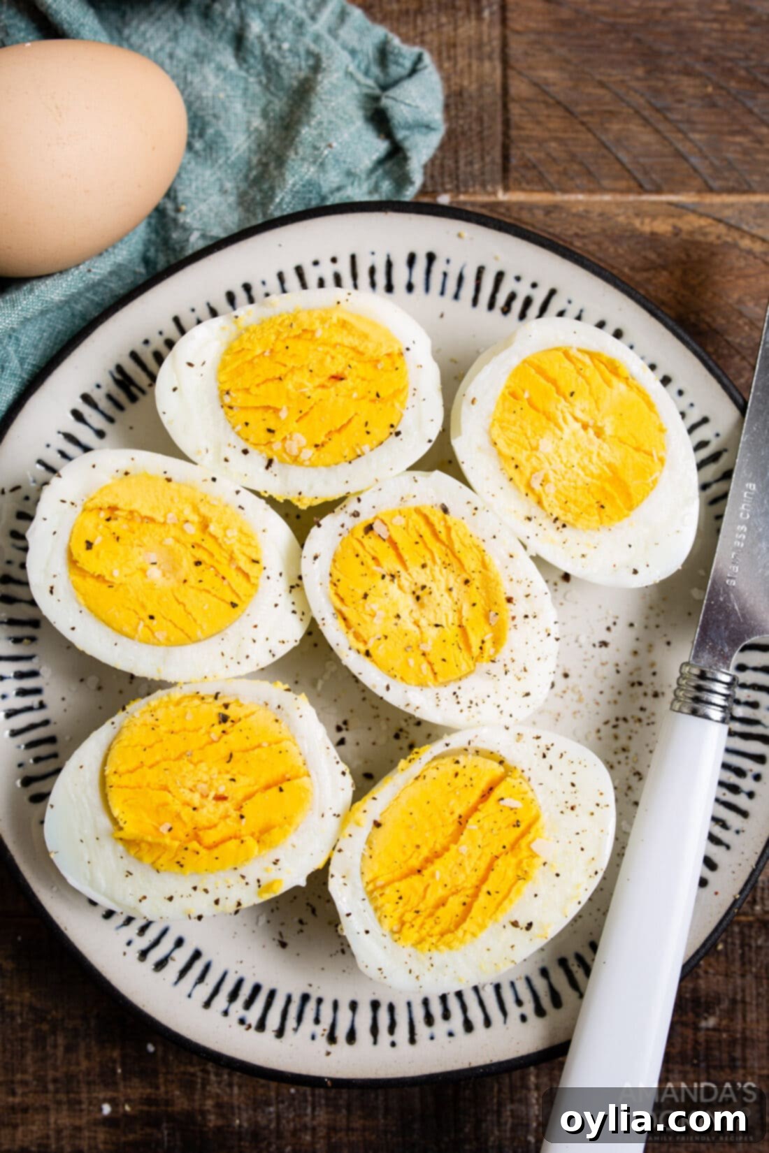Your Go To Air Fryer Hard Boiled Eggs 2 Two halved air fryer hard boiled eggs on a white plate, showing perfectly firm yolks and whites.