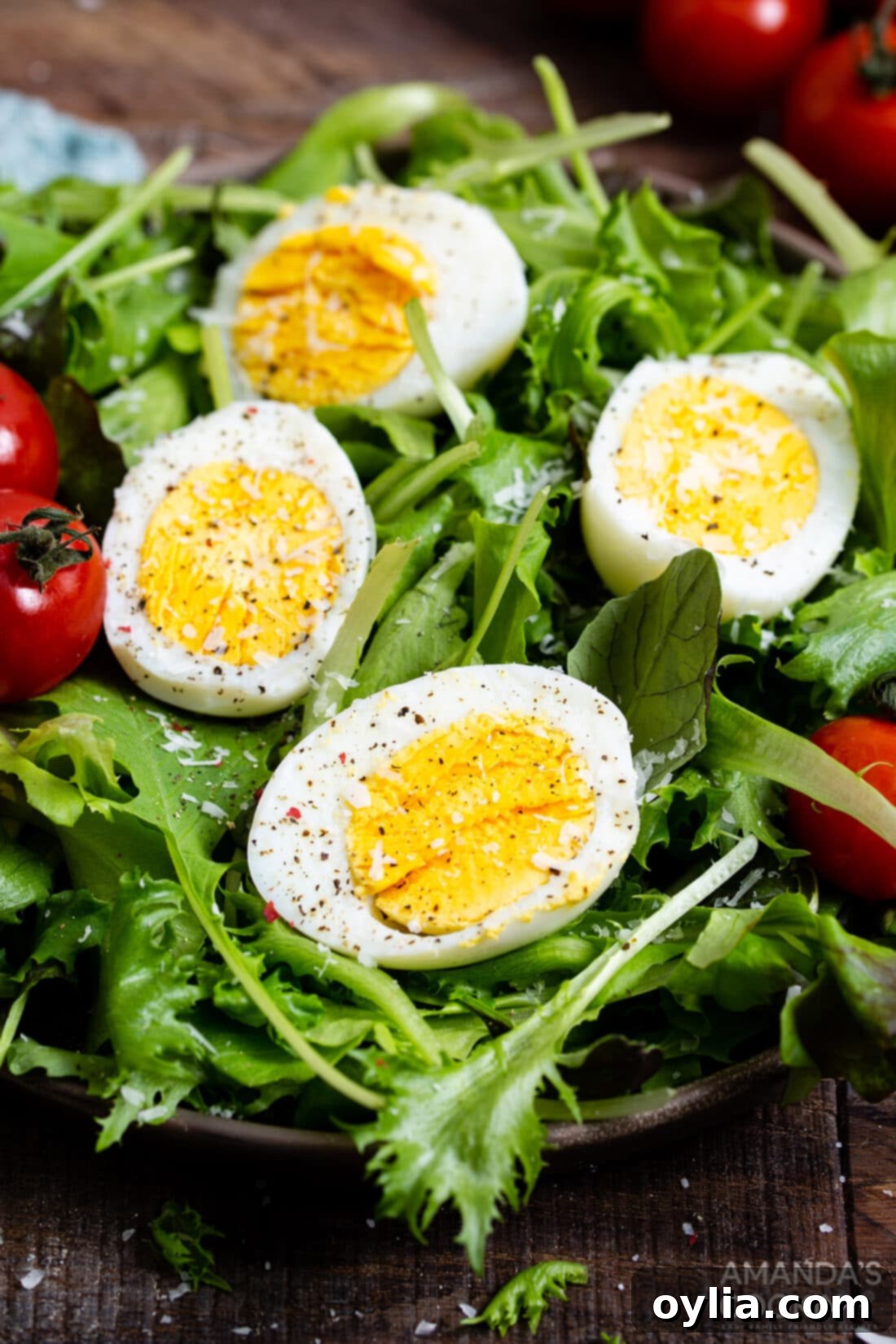 Your Go To Air Fryer Hard Boiled Eggs 3 Sliced air fryer hard boiled eggs neatly arranged on a vibrant green salad, showcasing a healthy meal.