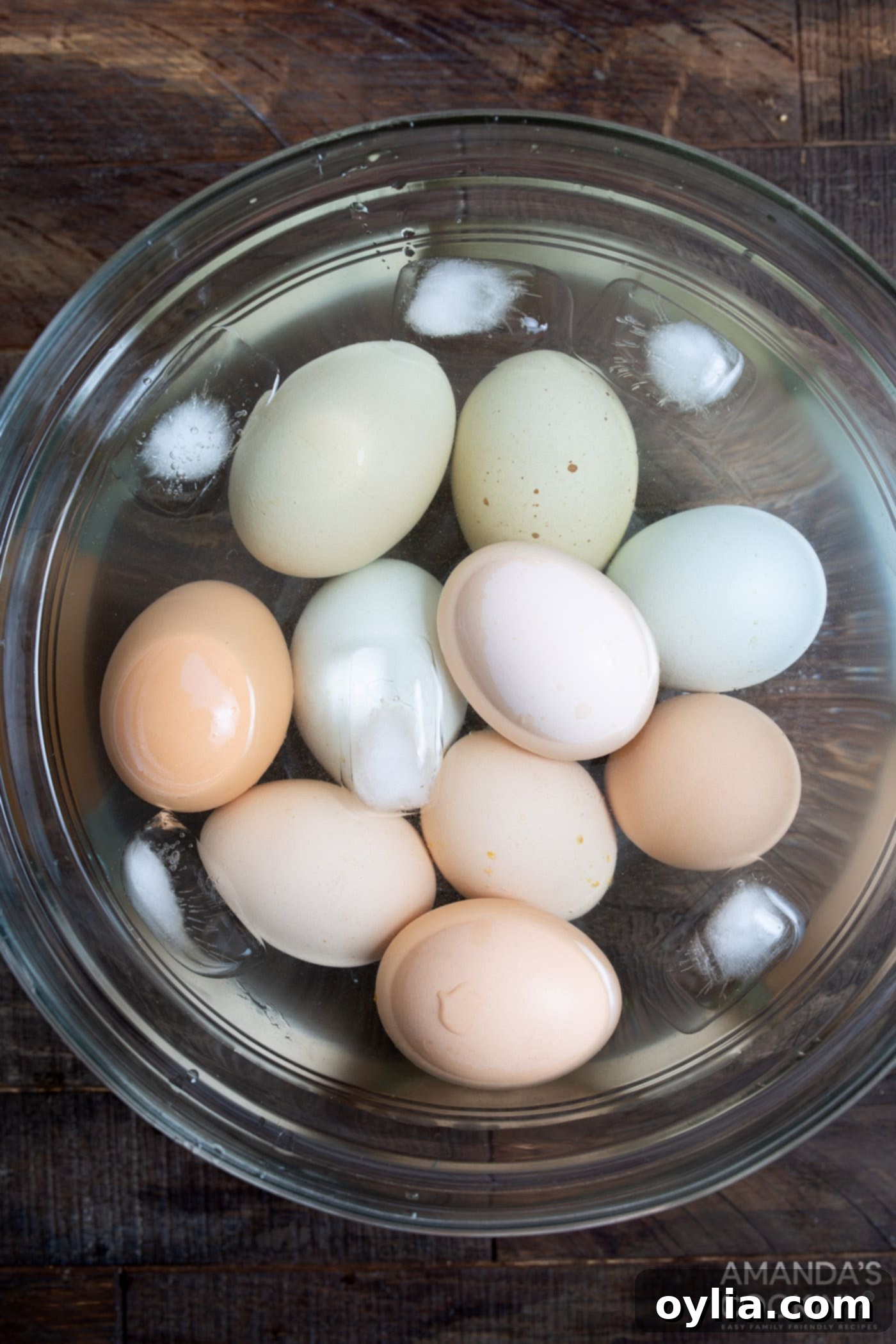 Freshly air-fried eggs submerged in a bowl of ice water, ensuring a quick cool-down for easy peeling.