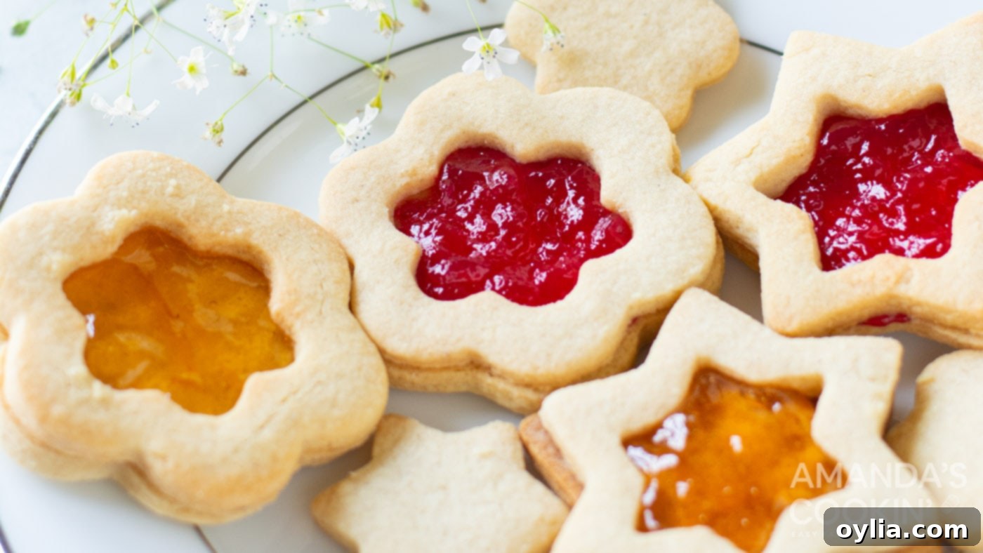Beautifully assembled Linzer cookies on a plate, filled with vibrant jam and delicately dusted with powdered sugar, ready for serving or gifting.