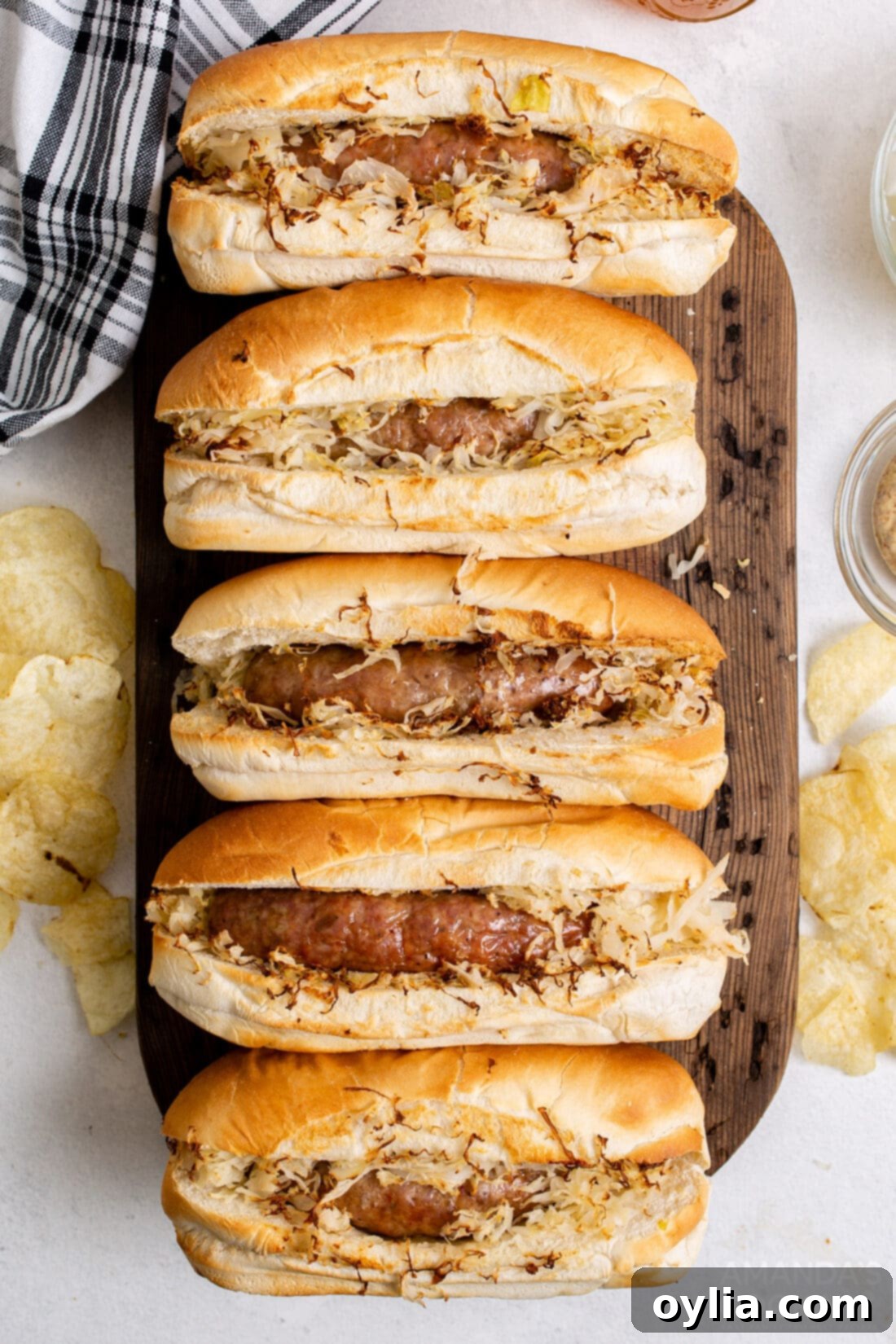 Perfect Air Fryer Bratwurst 2 air fryer bratwurst in buns with sauerkraut on cutting board