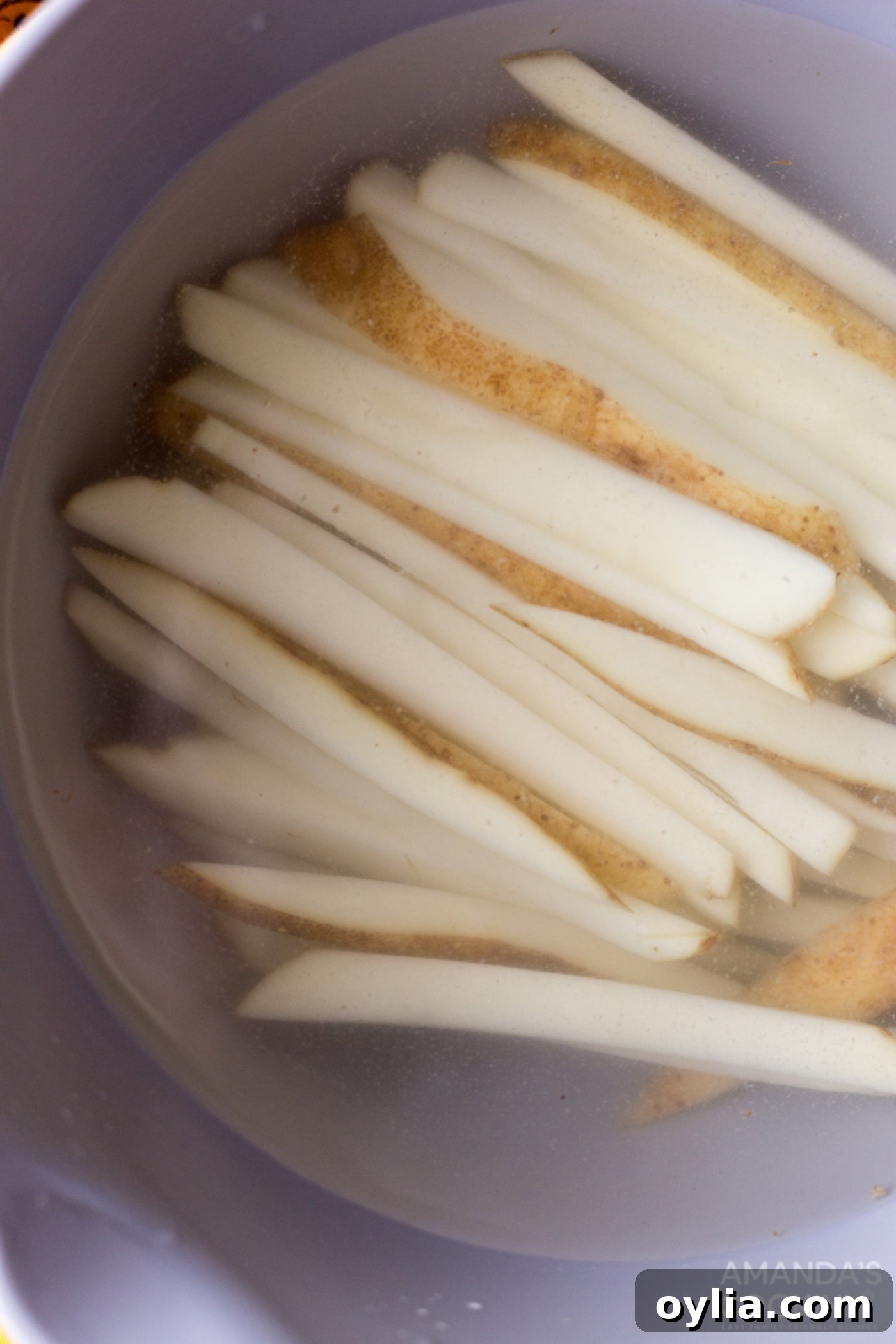 potato slices in a bowl of water
