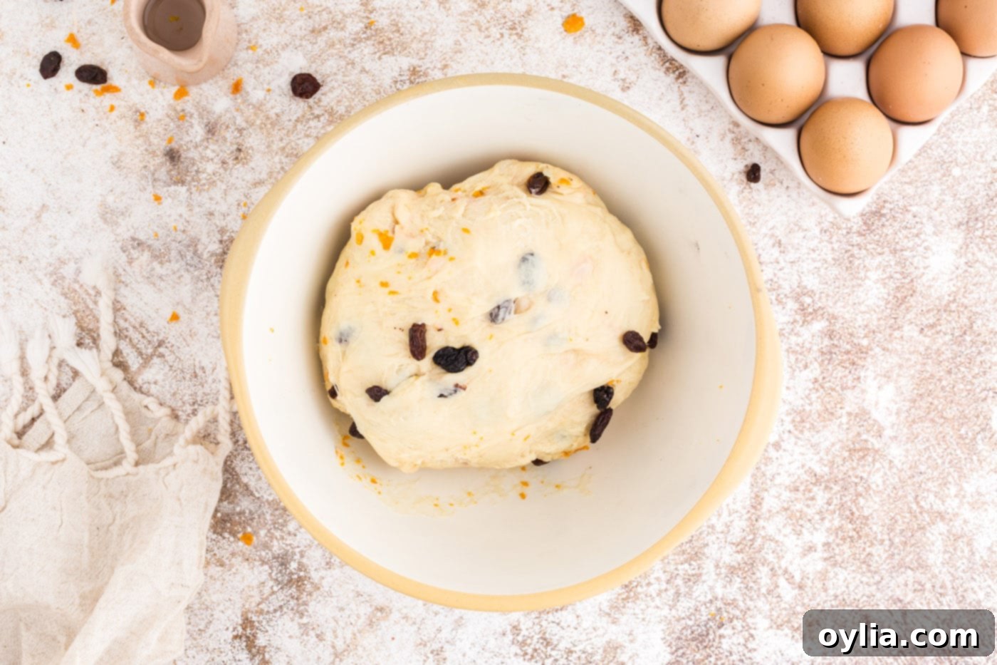 Raisins and candied orange peels being mixed into the dough