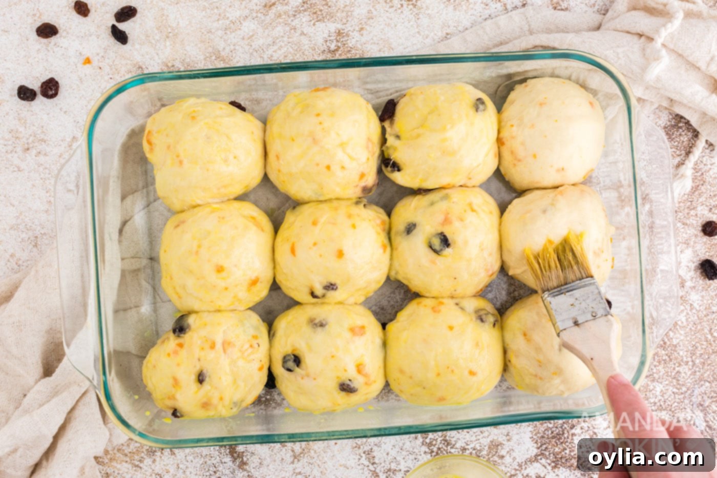 Brushing the tops of the dough balls with an egg wash before baking