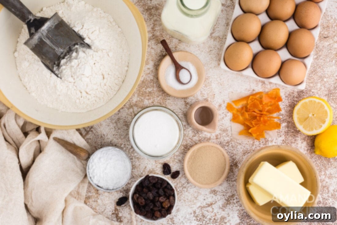 Assortment of ingredients for hot cross buns, including flour, yeast, milk, butter, eggs, raisins, and candied orange peels