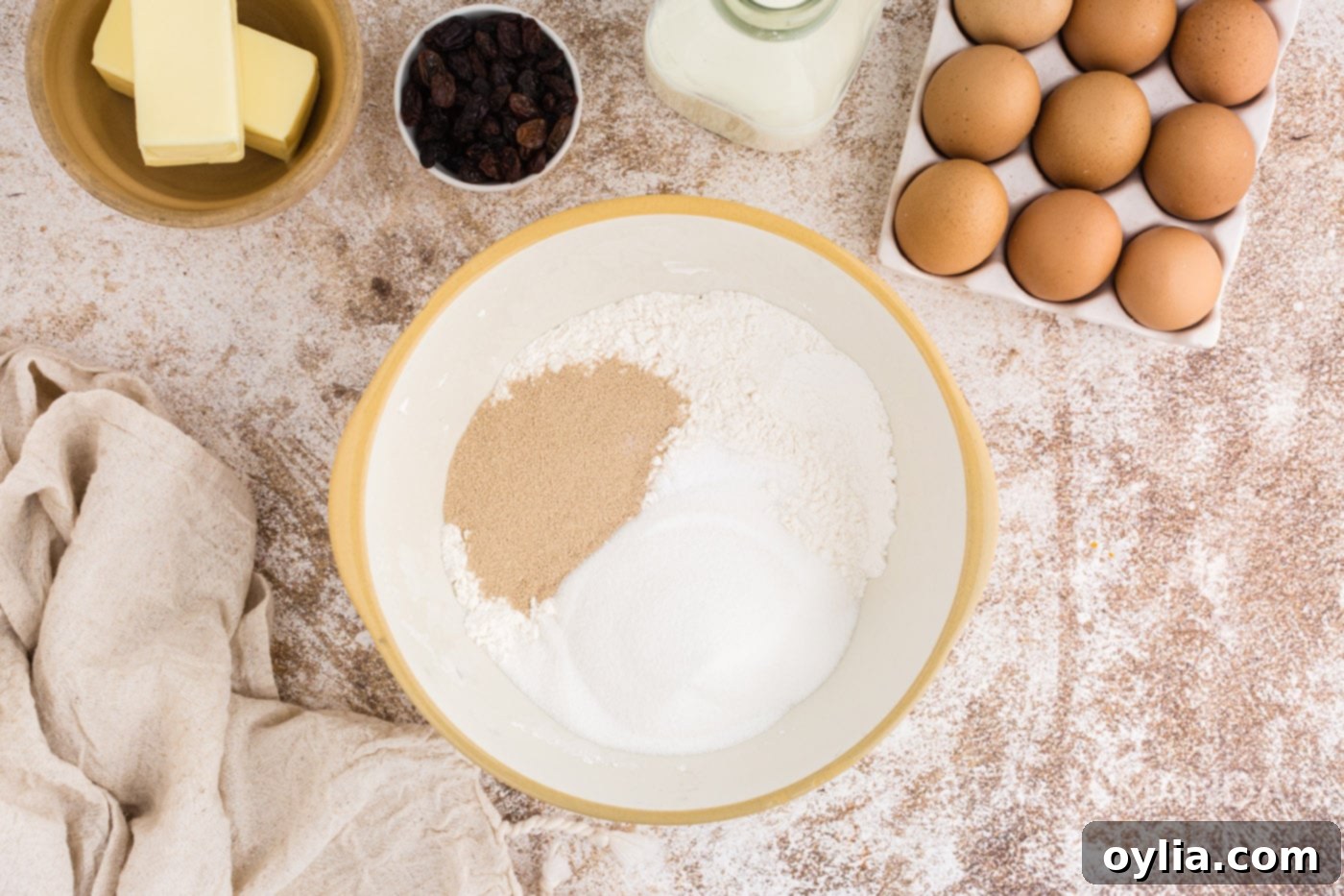 Sugar, yeast, and flour being combined in a mixing bowl
