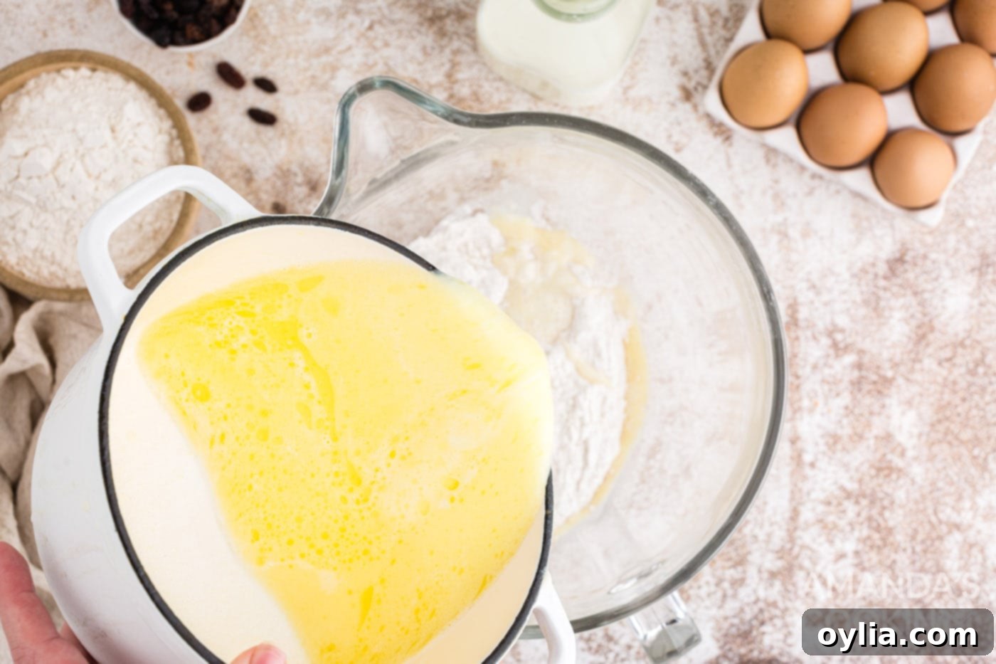Adding warm wet ingredients to dry ingredients in a mixer bowl