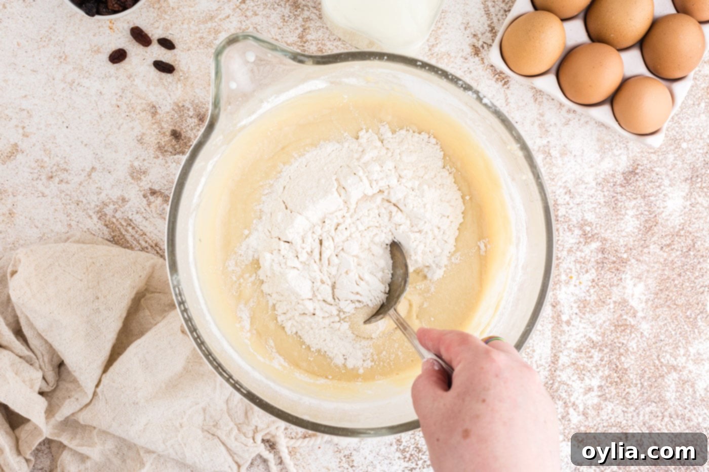 Stirring extra flour into the mixing bowl with a spoon to achieve soft dough