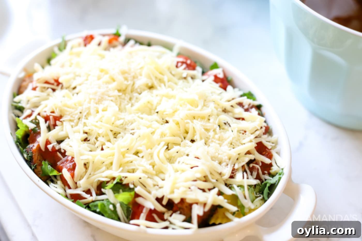 mozzarella cheese on top of spinach and sauce in a dish