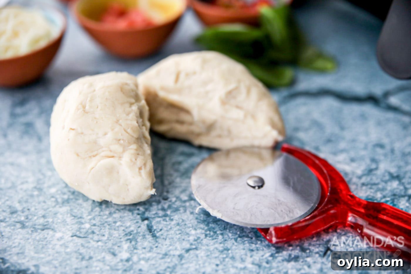 pizza dough cut in half, ready to be shaped