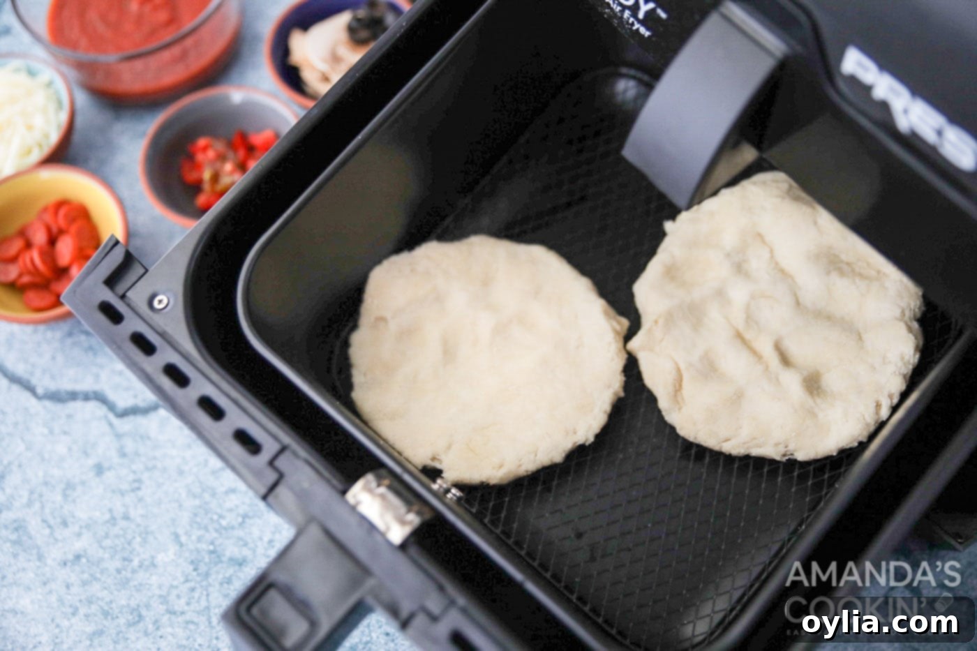 pizza dough circles placed in an air fryer basket