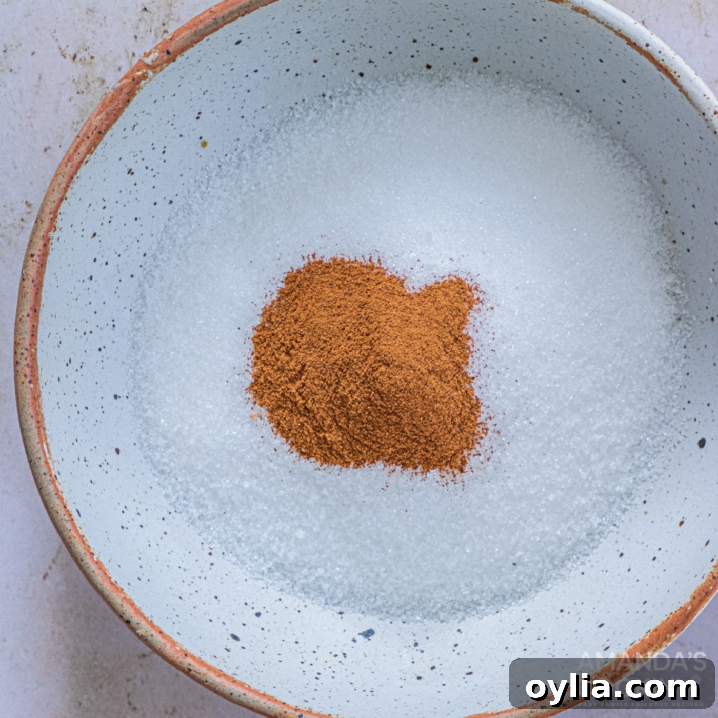Granulated sugar and ground cinnamon mixed together in a shallow bowl for the churro coating.