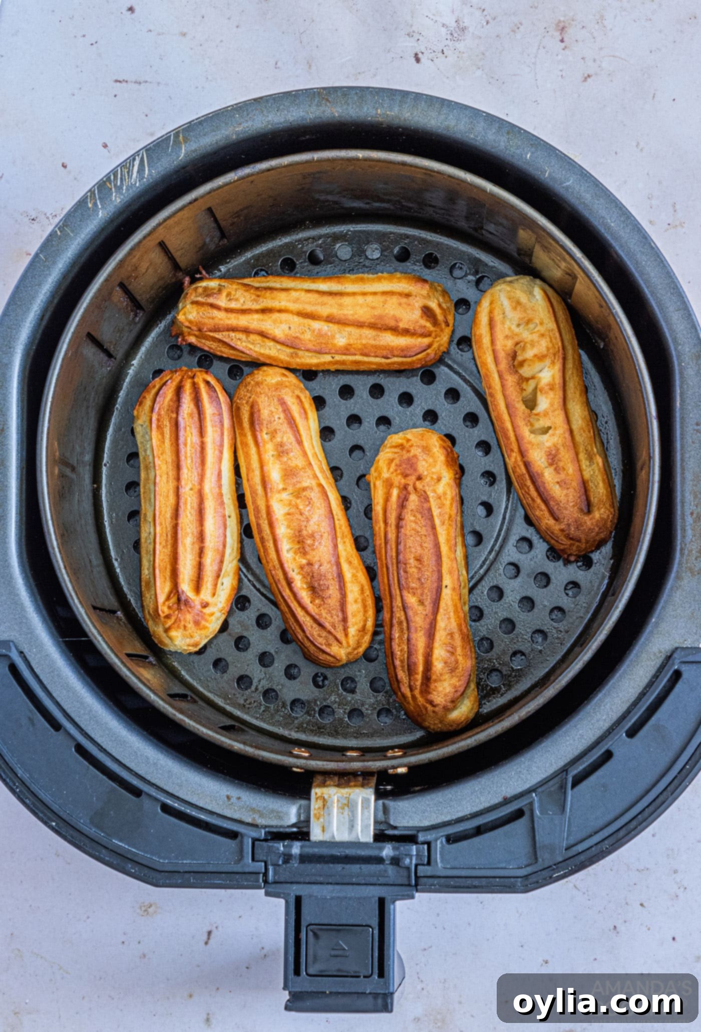 Golden brown air-fried churros arranged in an air fryer basket after cooking.