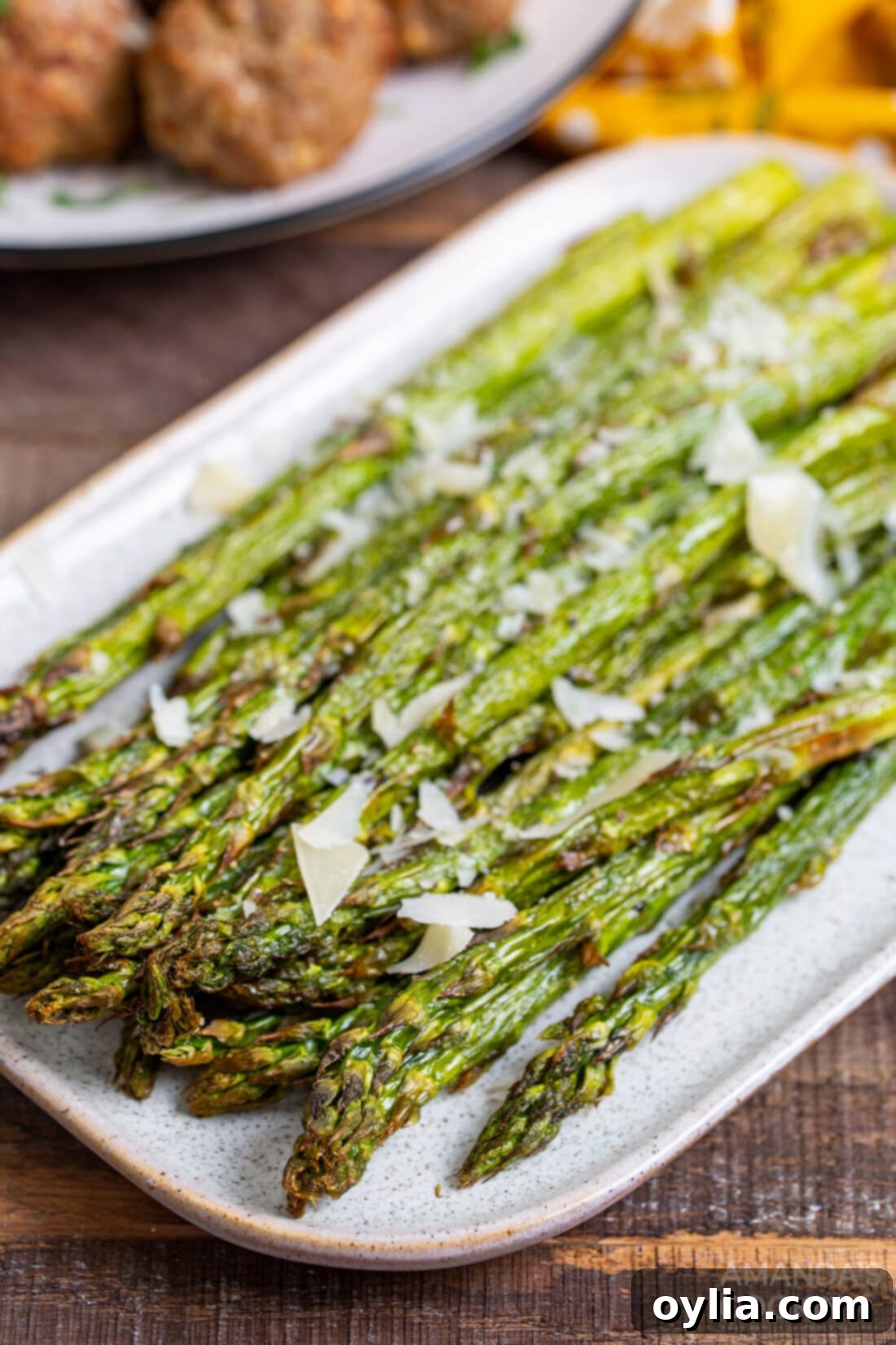 fresh asparagus spears seasoned on a plate, ready to be cooked