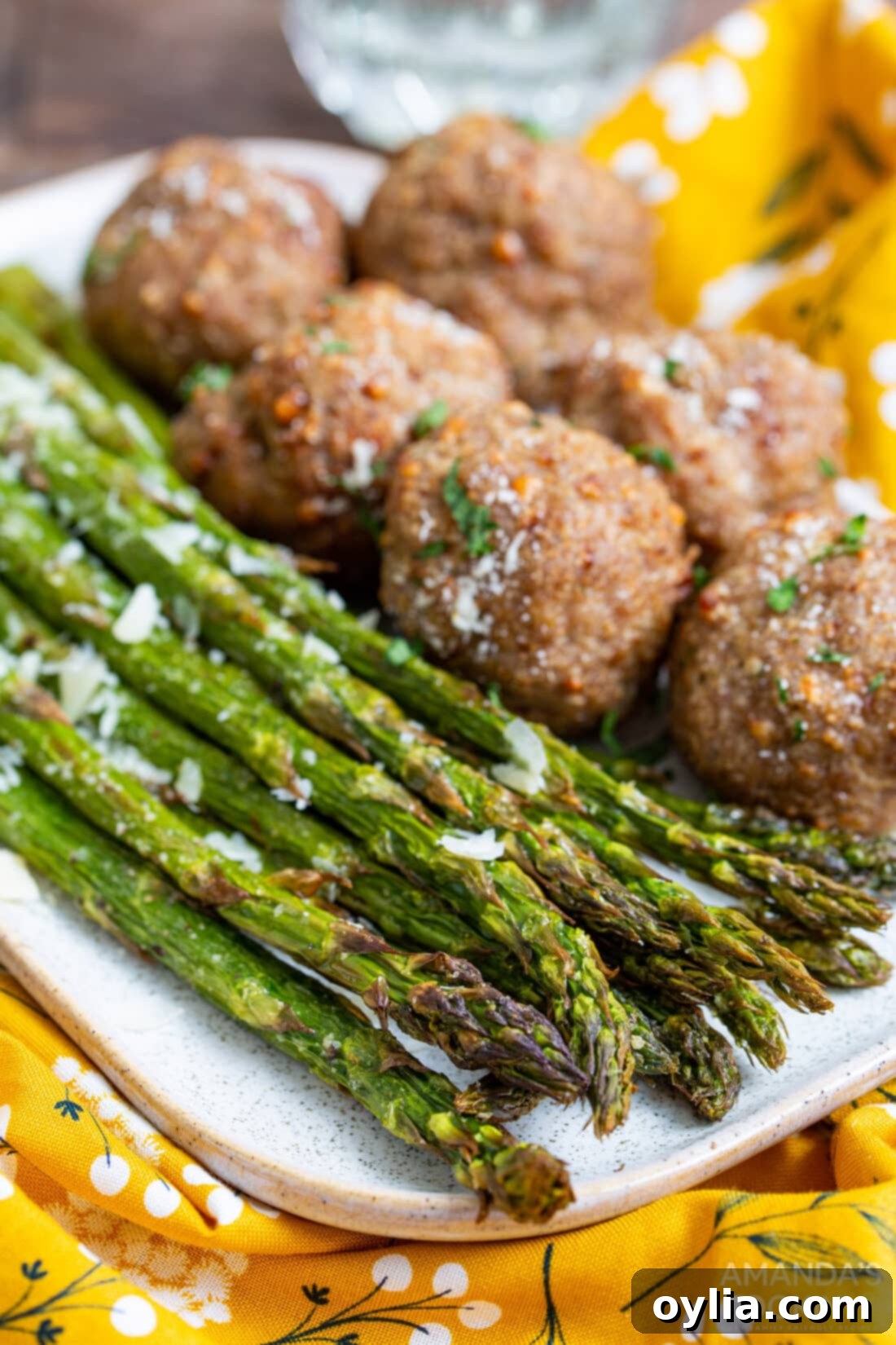 Air Fryer Asparagus served alongside juicy meatballs for a complete meal