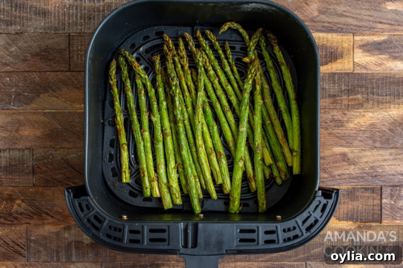 perfectly cooked asparagus spears in the air fryer basket