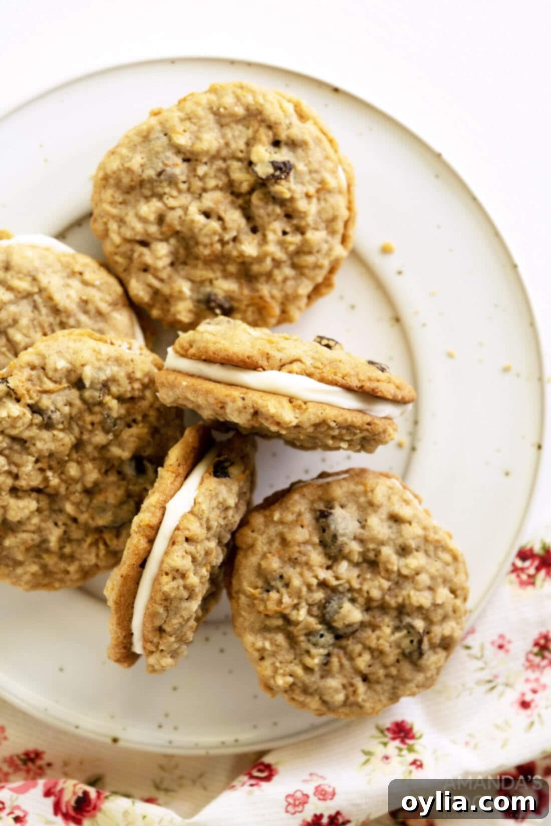 Carrot Cake Whoopie Pies 2 Carrot Cake Sandwich Cookies on a plate, showcasing their soft texture and creamy filling.