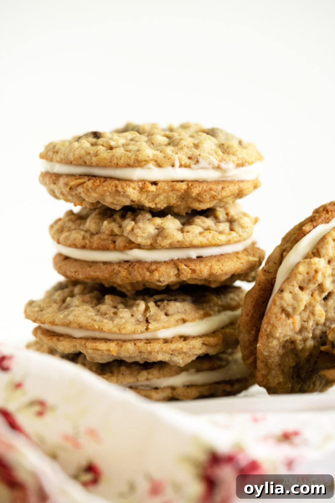 Carrot Cake Whoopie Pies 13 Stack of beautifully frosted Carrot Cake Sandwich Cookies on a white plate, ready to be served.