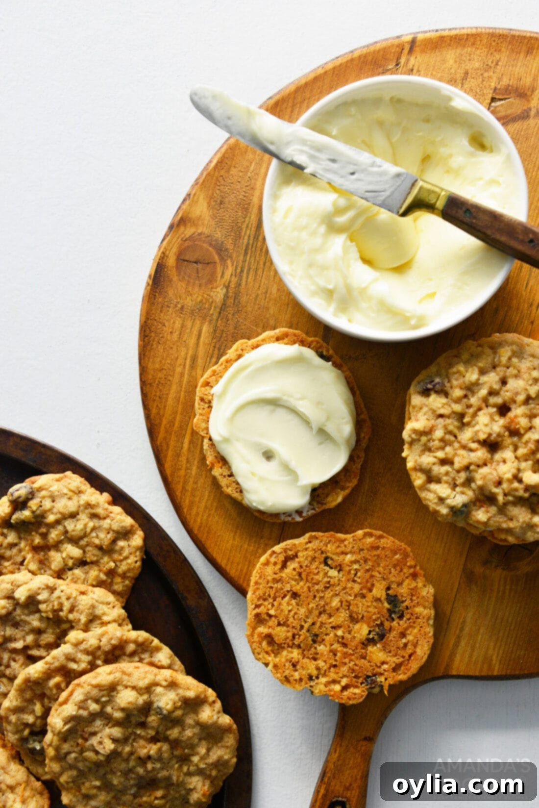 Carrot Cake Whoopie Pies 3 Close-up of a hand spreading cream cheese frosting onto a carrot cake oatmeal cookie.