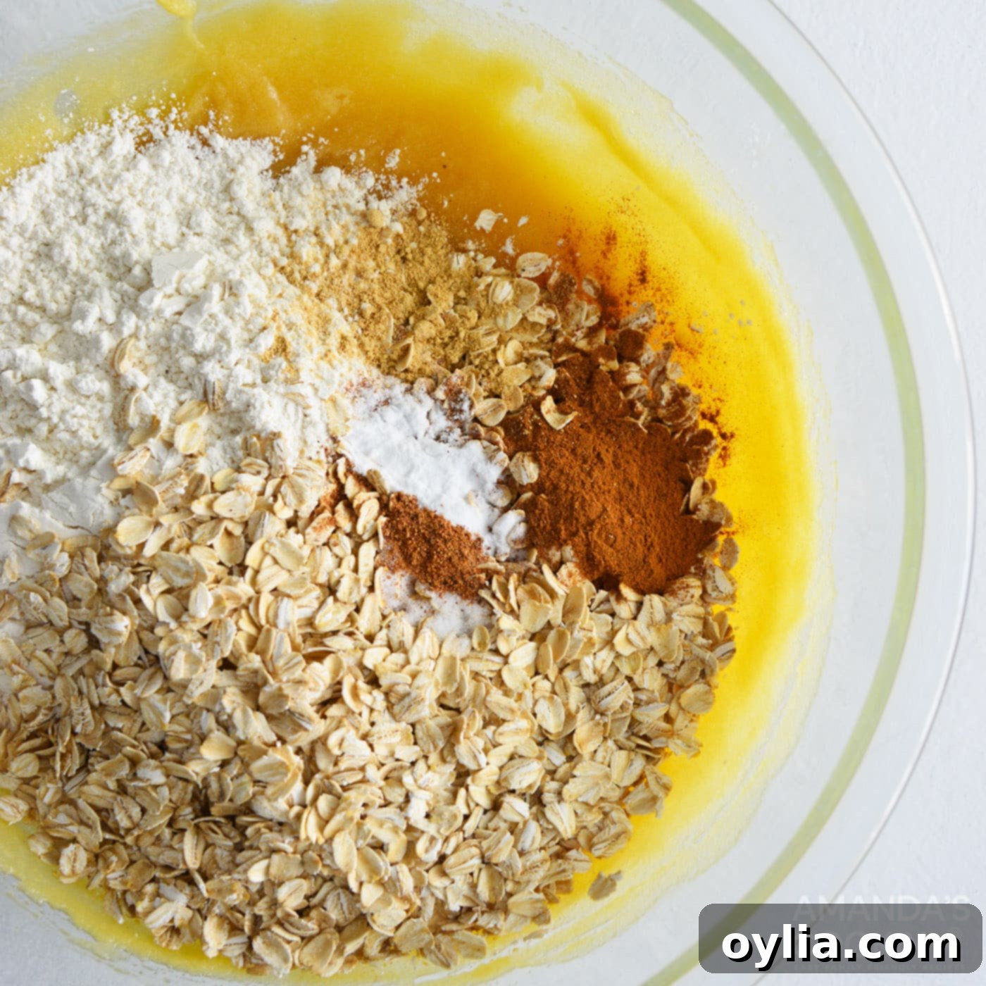 oats, flour, and spices added to mixing bowl for cookie dough
