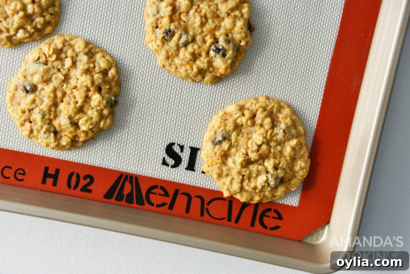 baked carrot cake cookies on a tray, showing golden edges