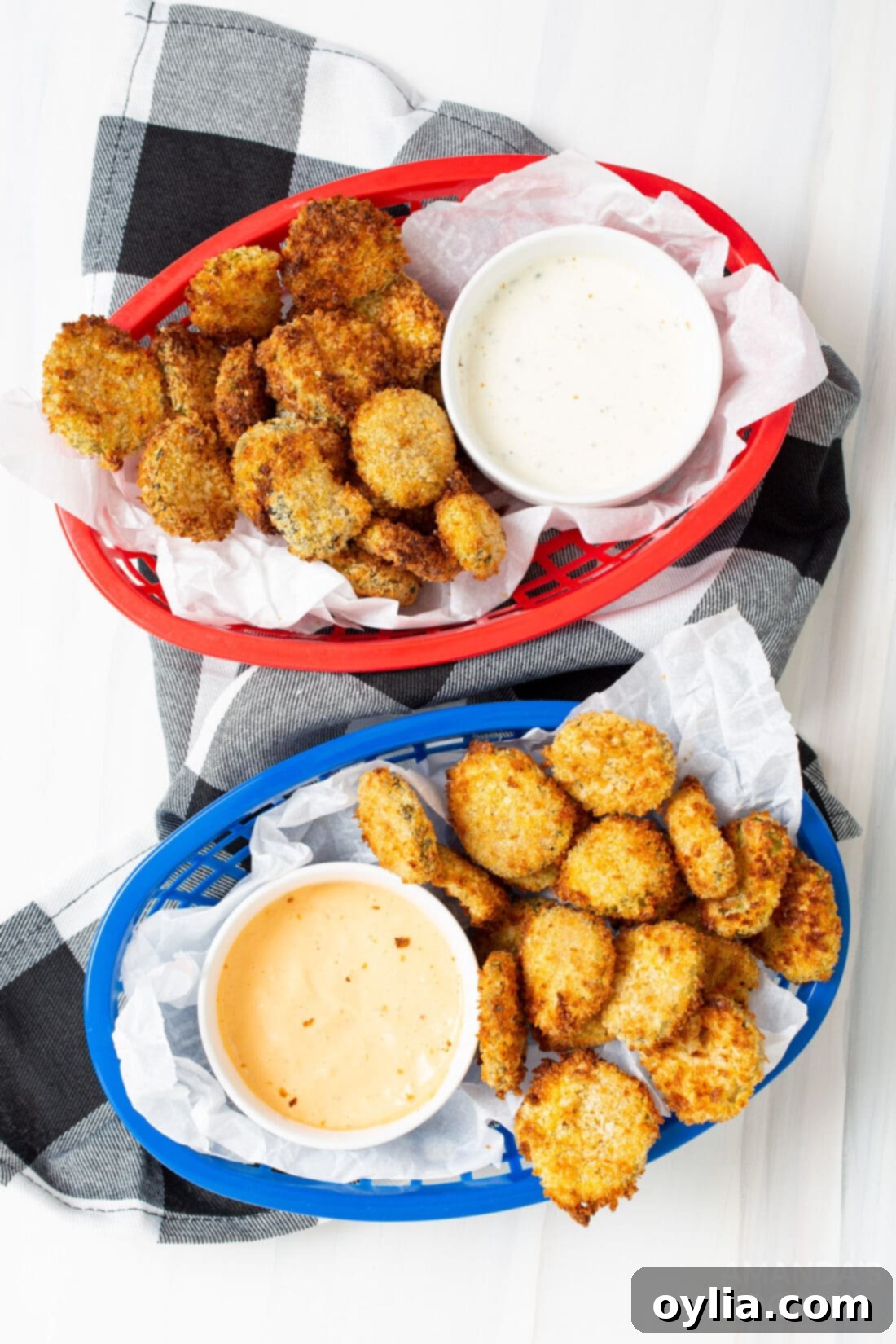 Two baskets filled with golden brown, crispy air fryer fried pickles, ready to serve.