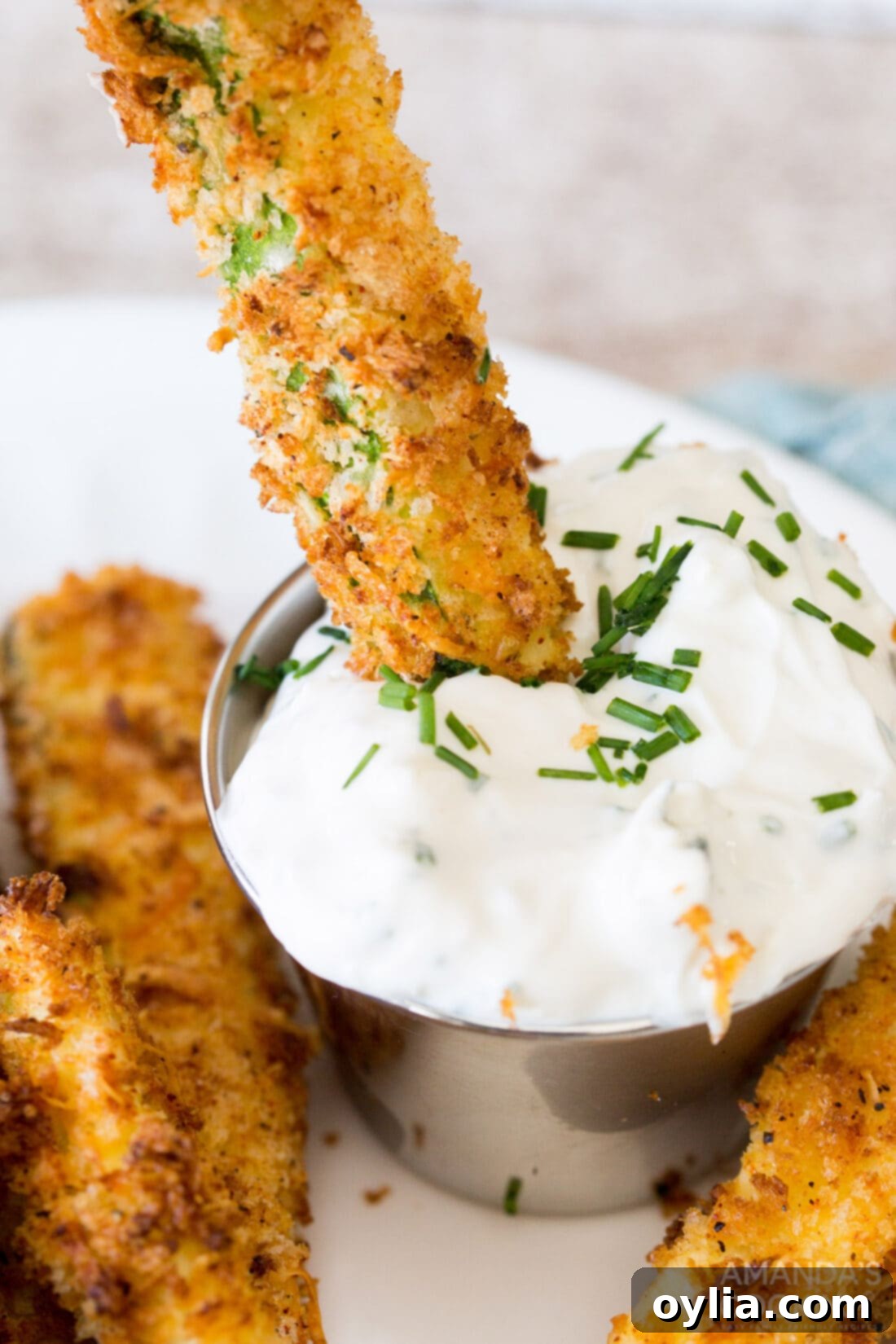 dipping an air fryer zucchini fry into sauce