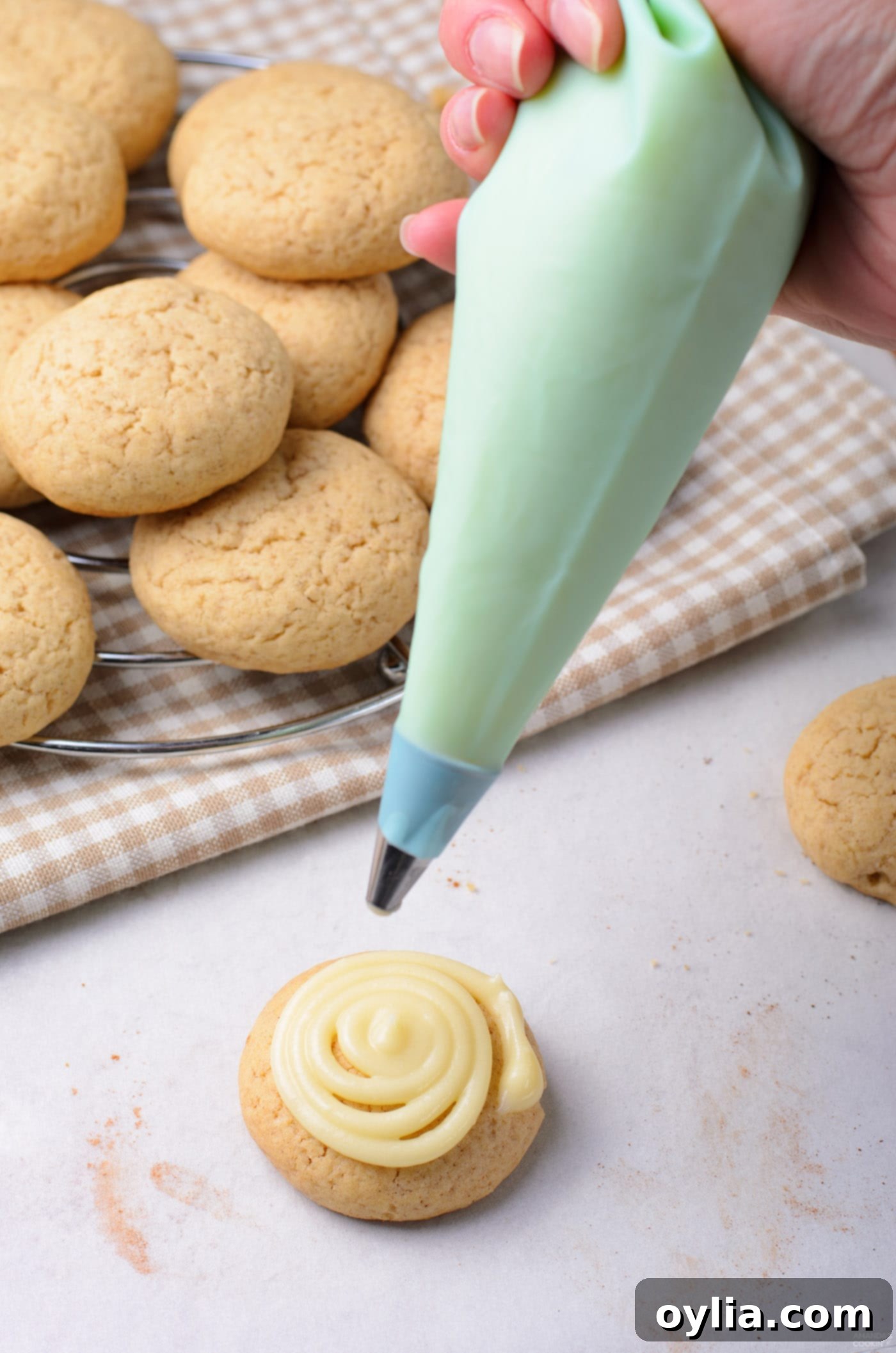 adding cream cheese frosting to cookie