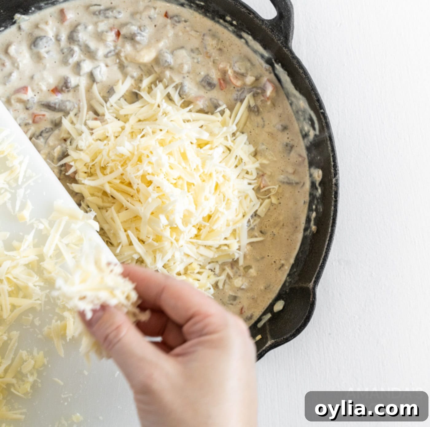 adding provolone to meat mixture in a skillet