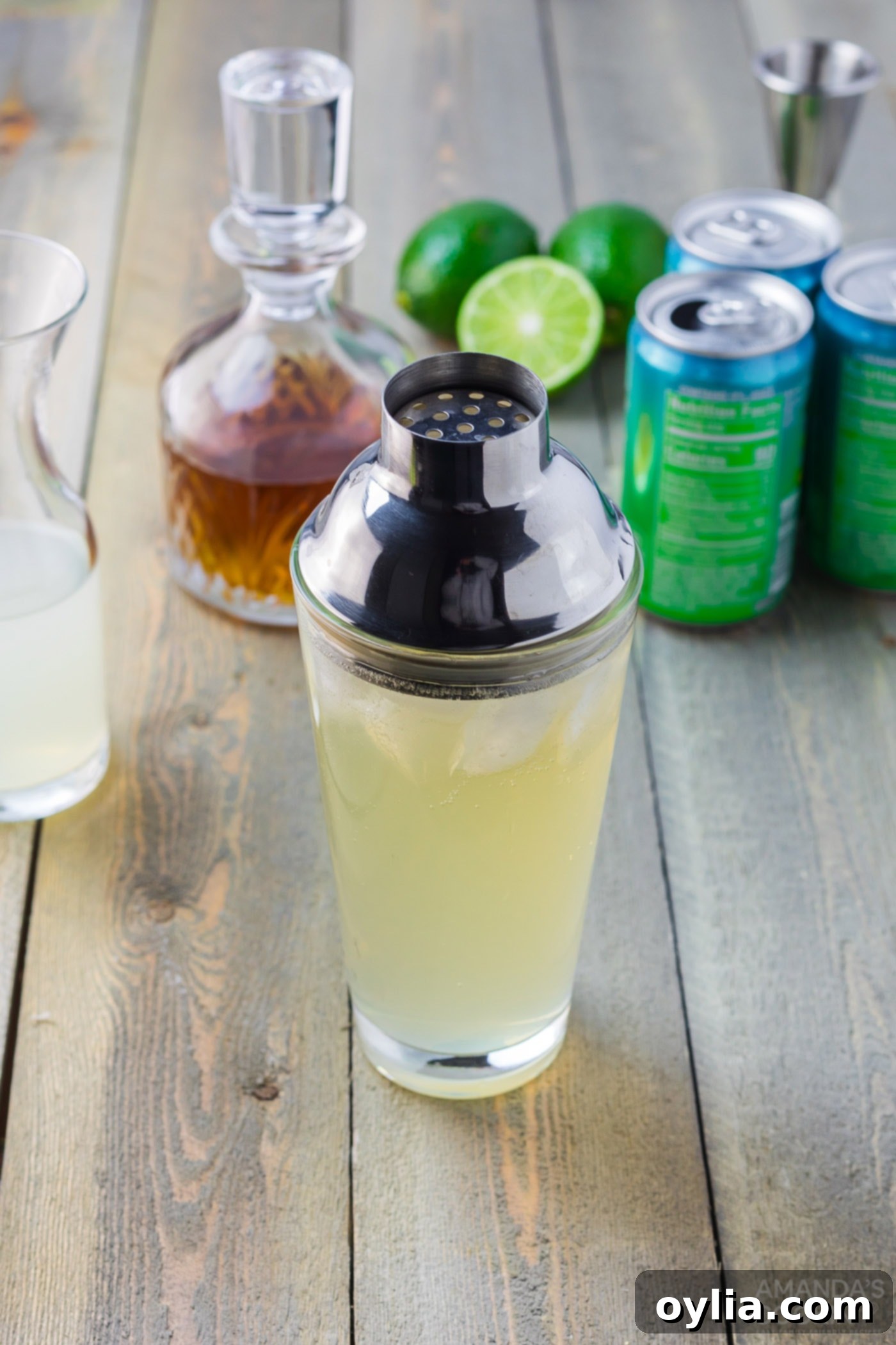 Spiked limeade being poured from a cocktail shaker into a glass